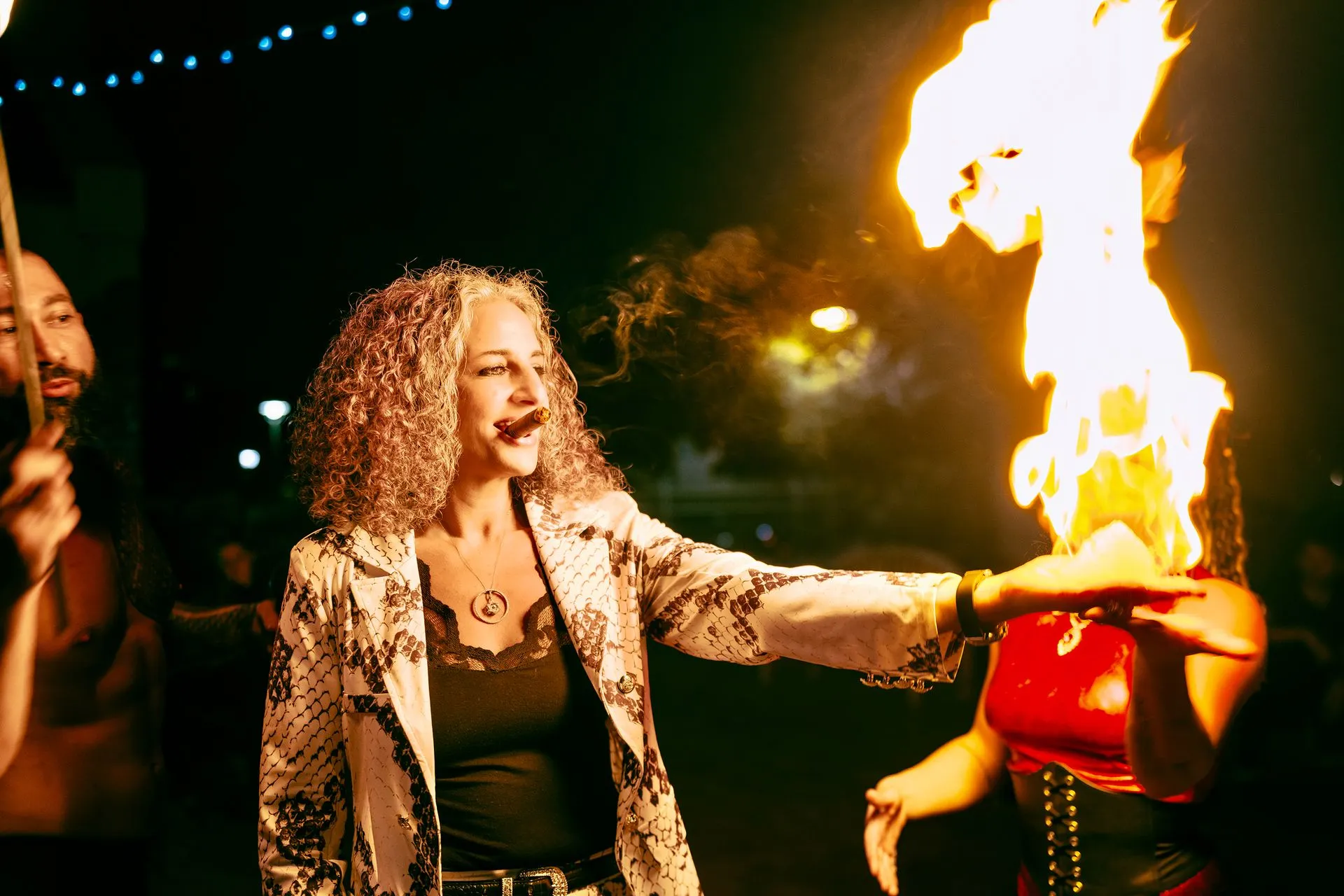 A woman is holding a torch with flames coming out of it.