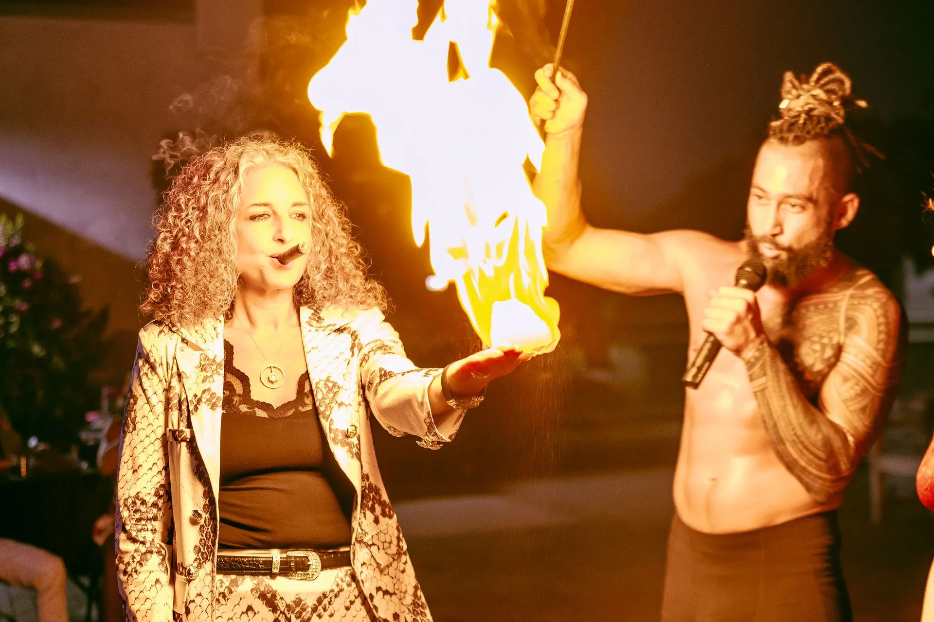 A man and a woman are holding a torch with flames coming out of it
