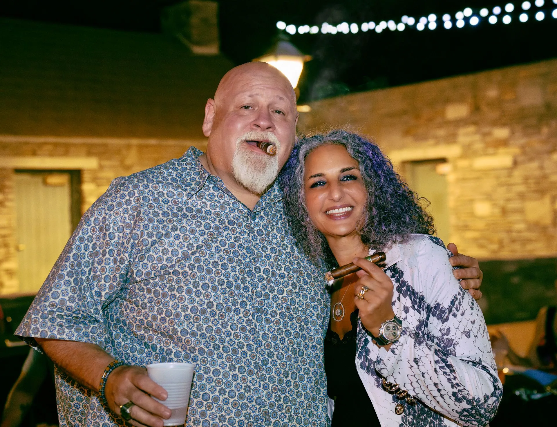 A man and woman holding cigards
