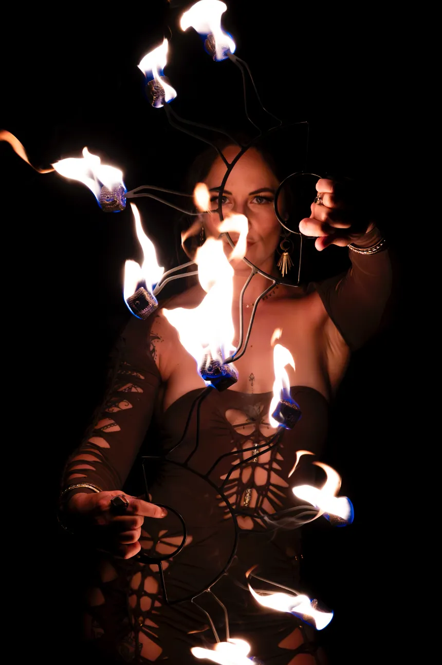 A woman is holding a bunch of fire in her hands.