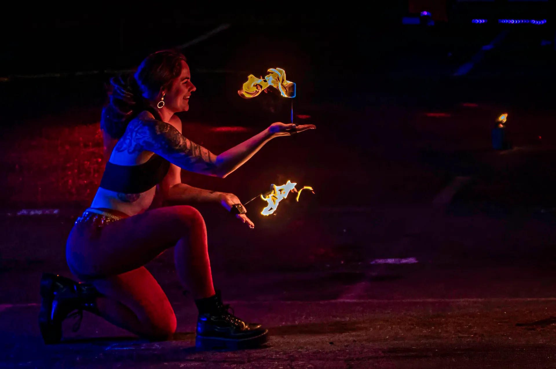 A female fire performing holding Palm Torches.