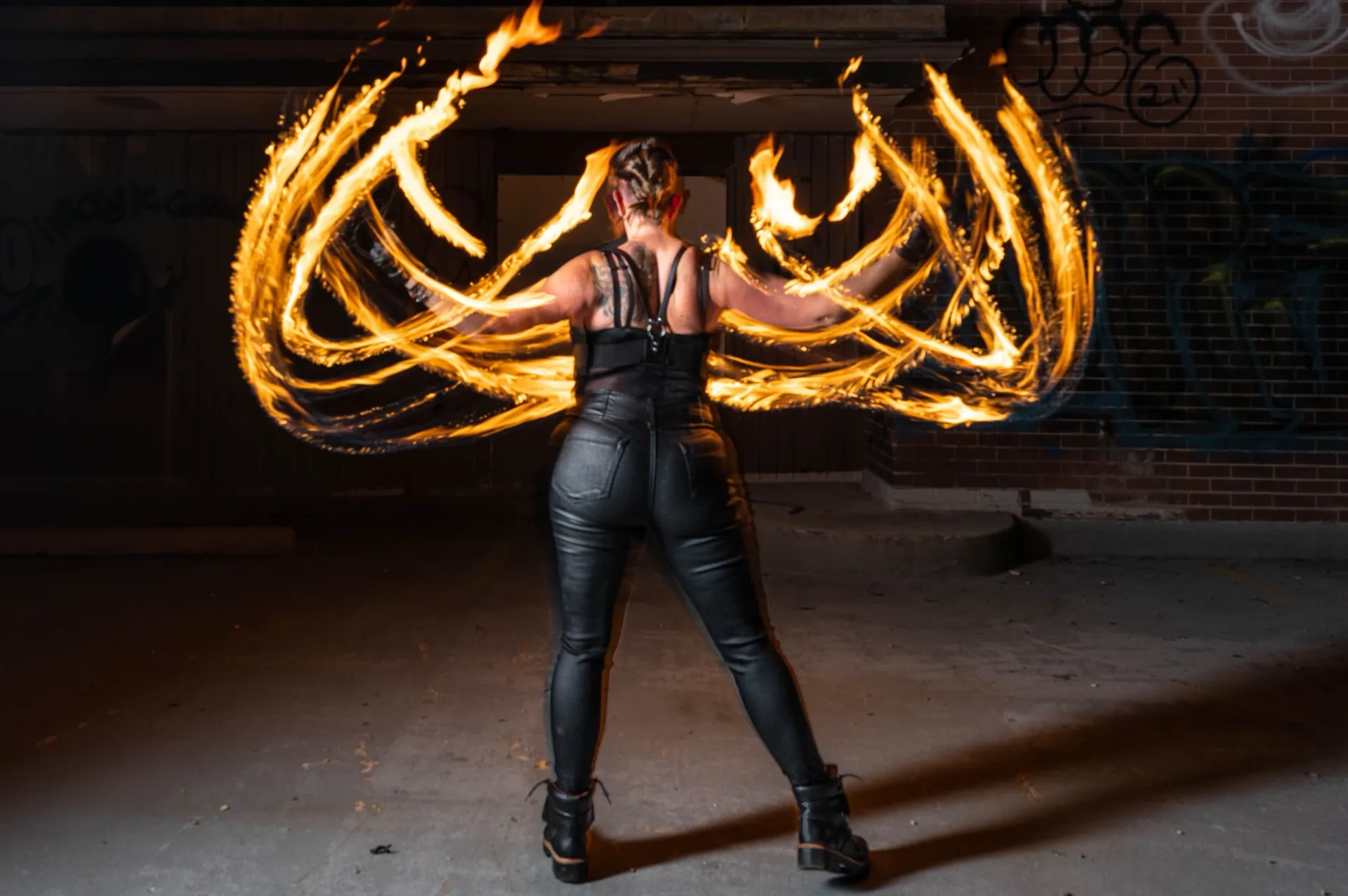 A woman performing with fire with blurred fire lines.