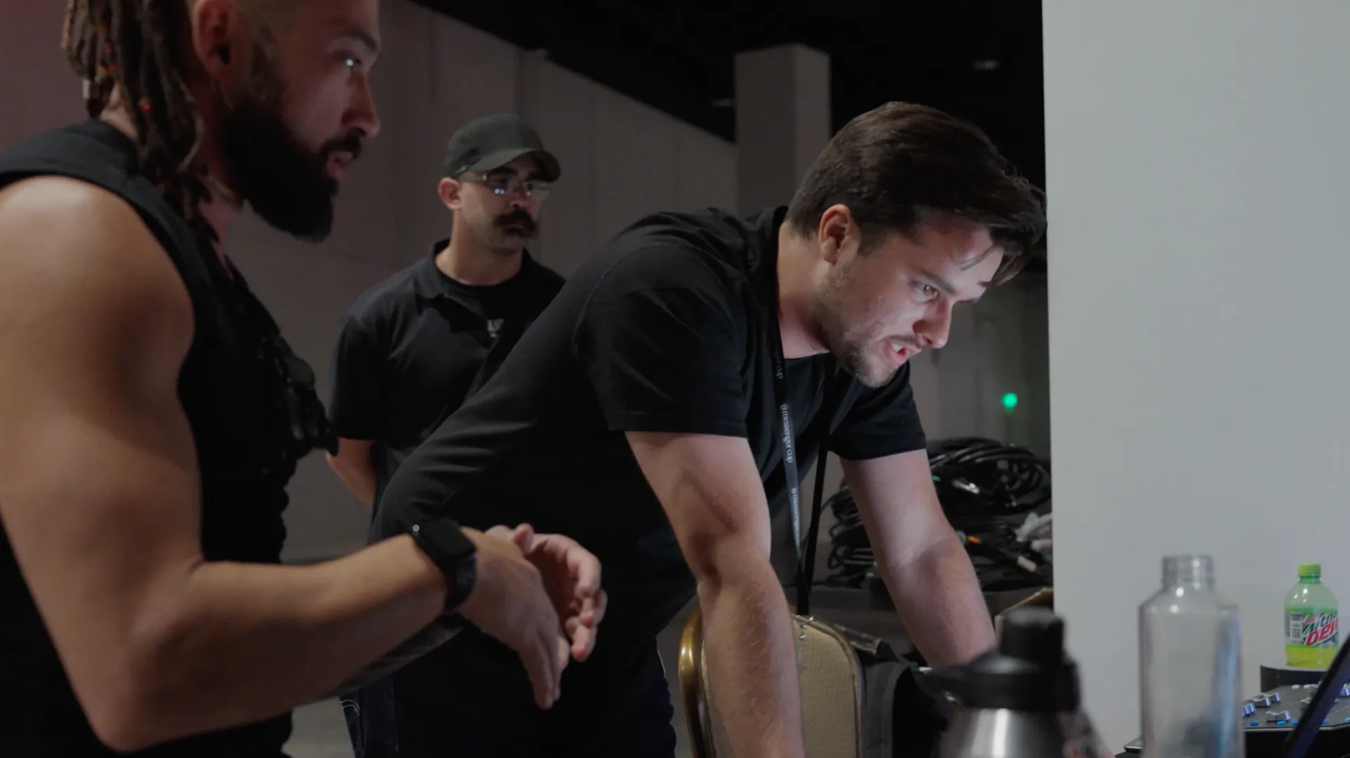 A group of men are standing around a table looking at something.