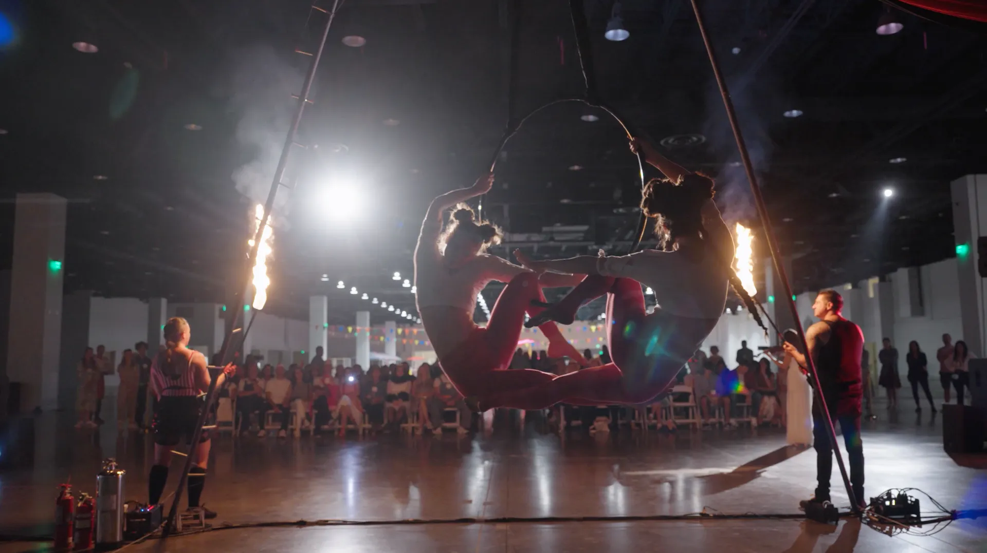 A group of people are performing aerial acrobatics in a dark room.