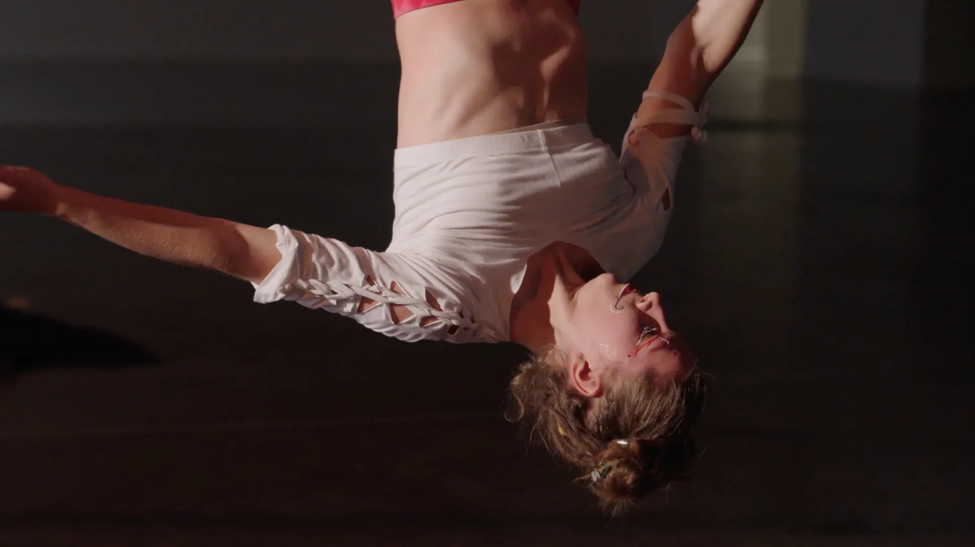 A woman is doing a handstand in a dark room.
