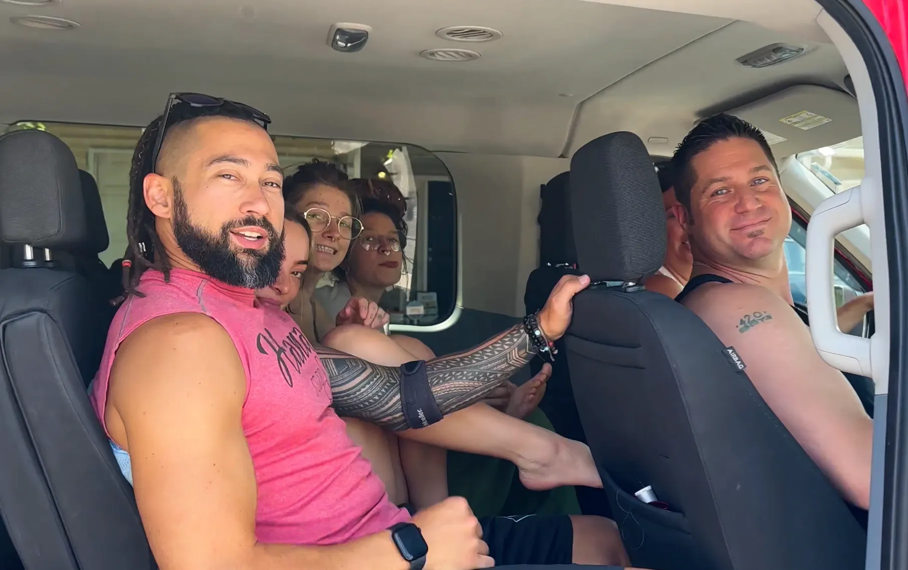 A group of people are sitting in the back seat of a car.