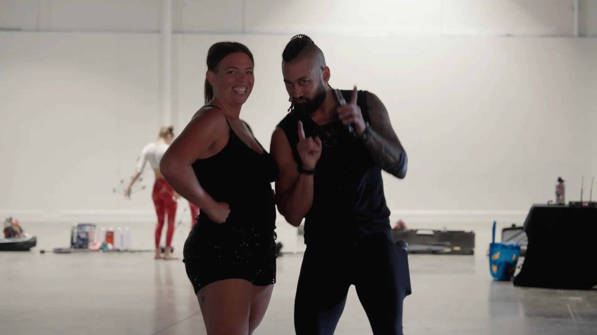 A man and a woman are standing next to each other in a gym.