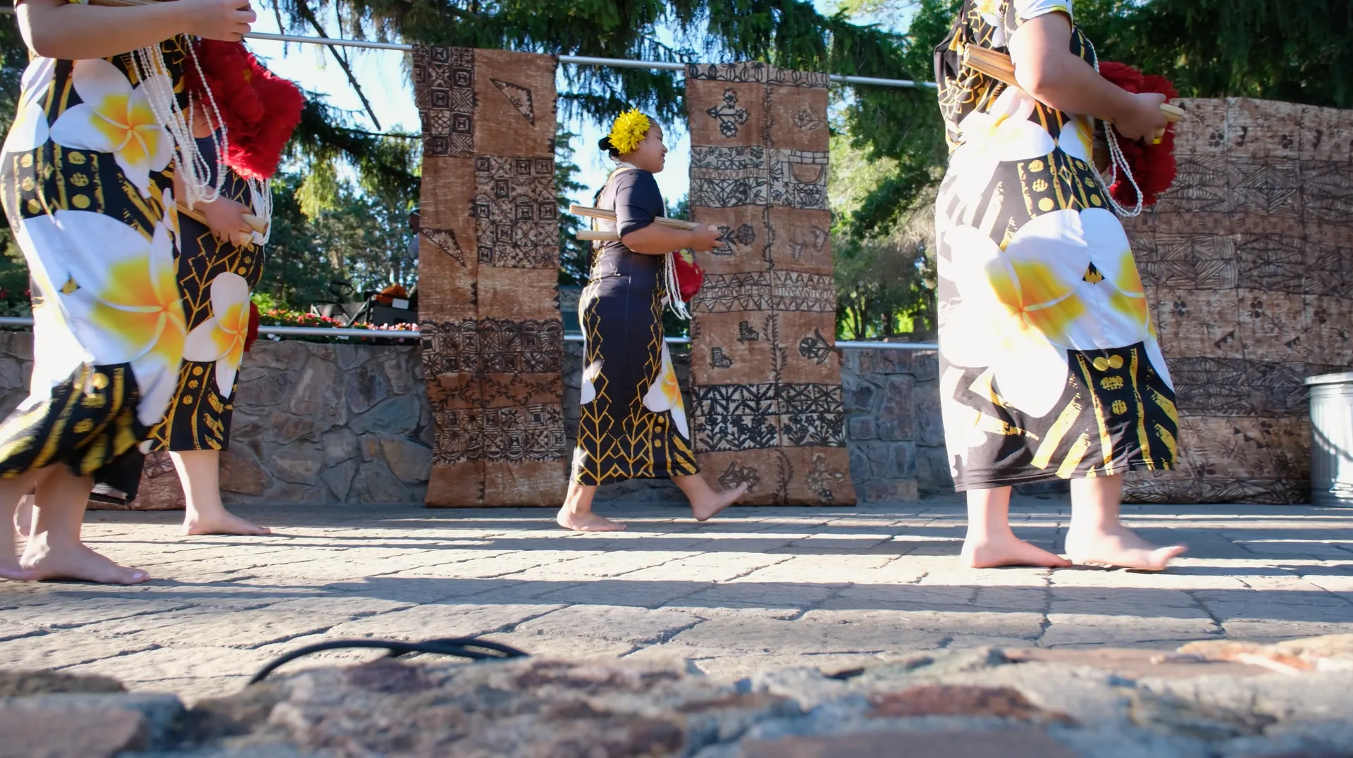 A group of women are walking barefoot on a sidewalk.