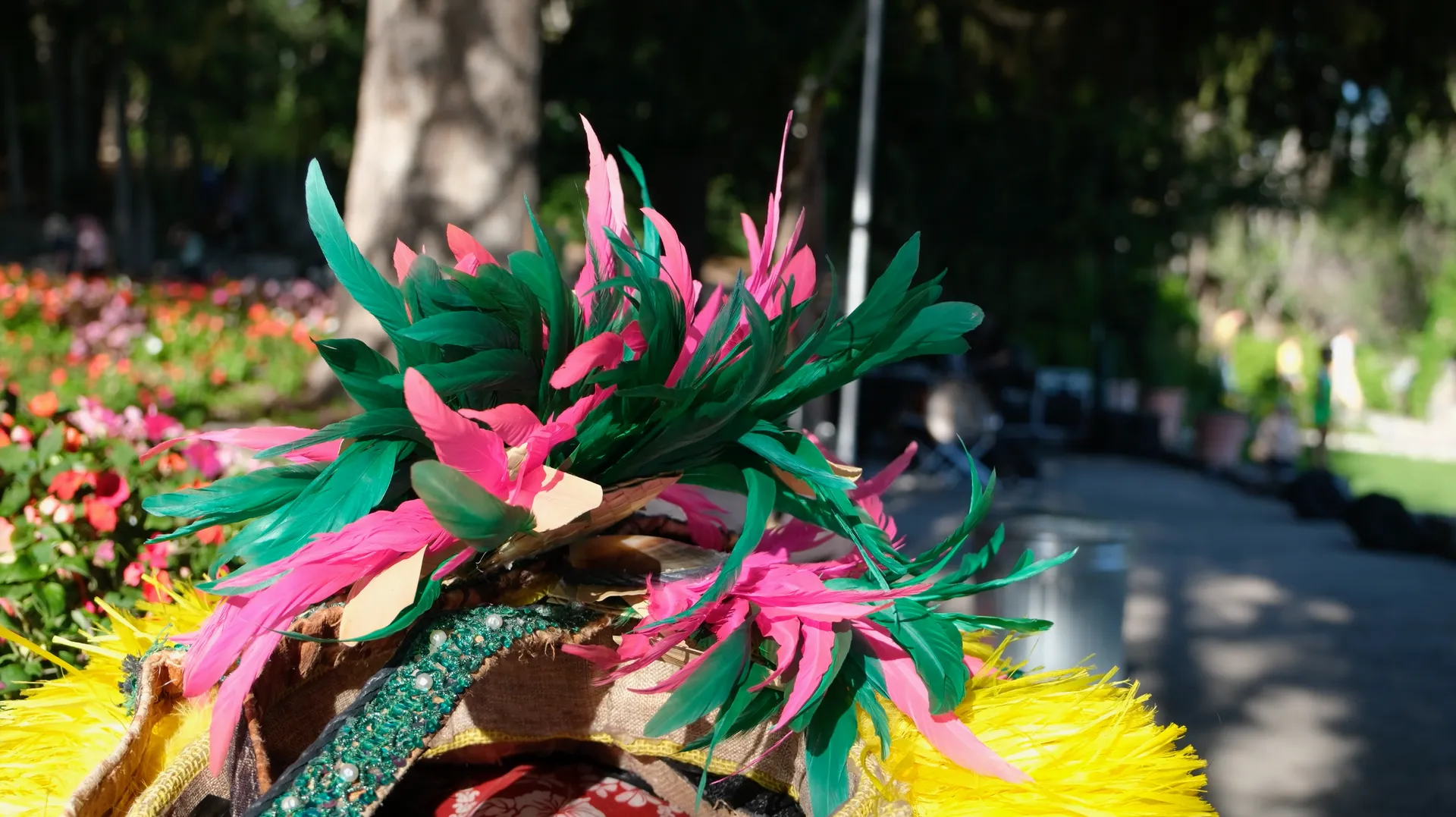 A colorful feathered hat is sitting on the side of a road.