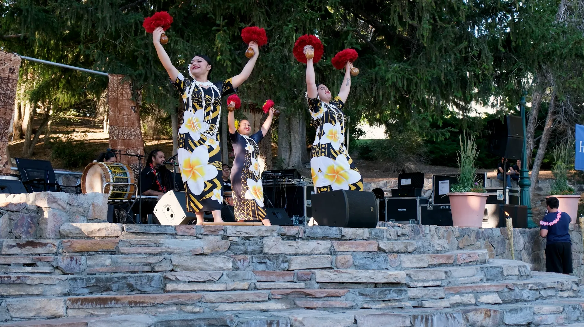 A group of people are standing on a stage holding flowers in their hands.