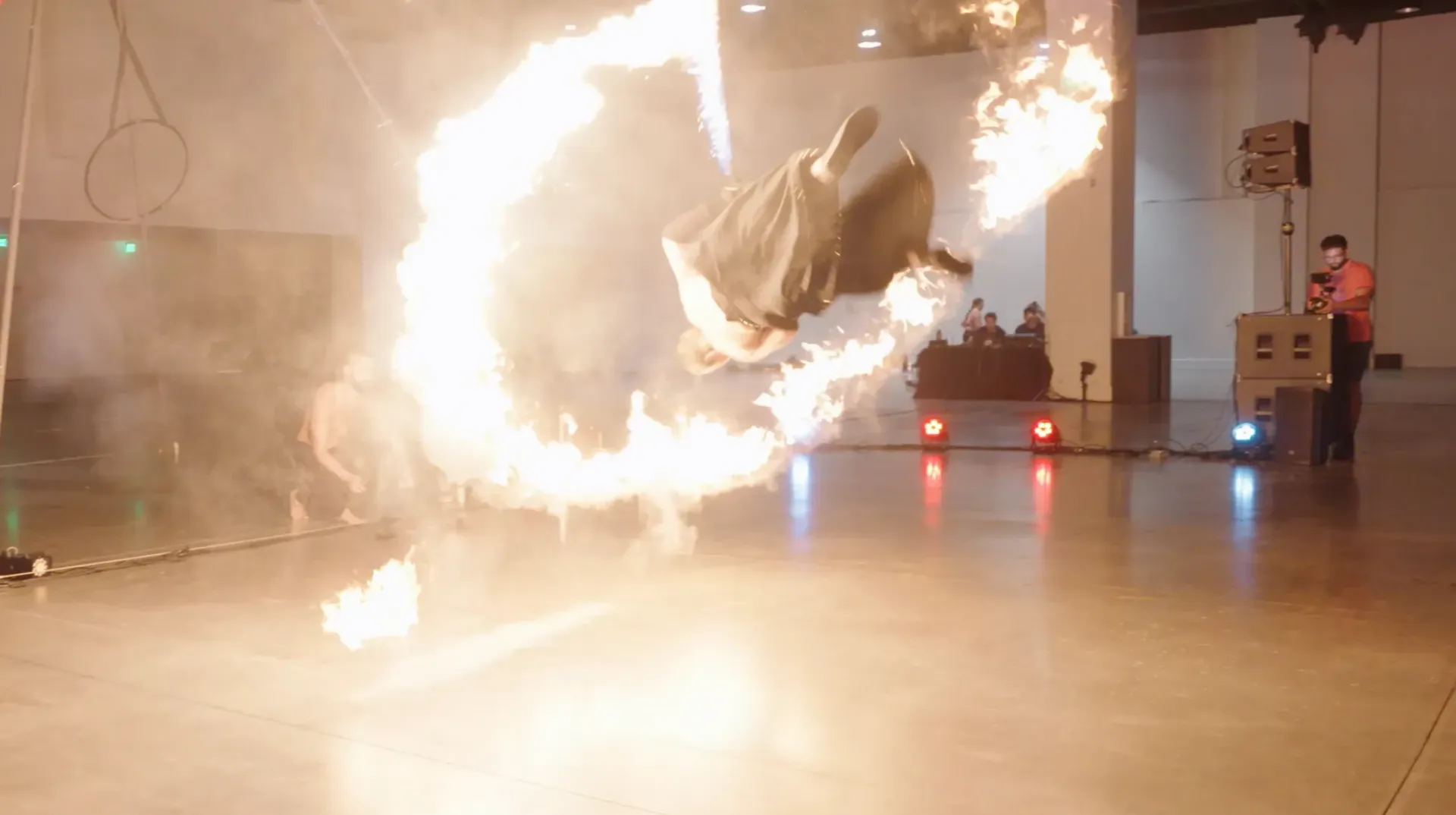 A person is doing a trick with fire in a room.