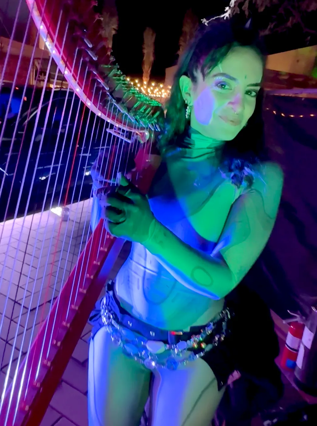 A woman is playing a harp in a dark room