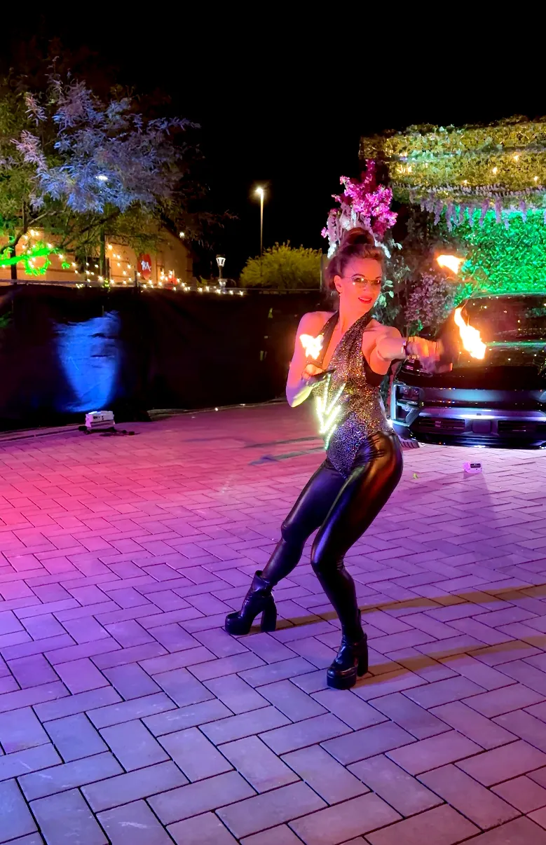 A woman in a costume is holding a fireball in her hands.