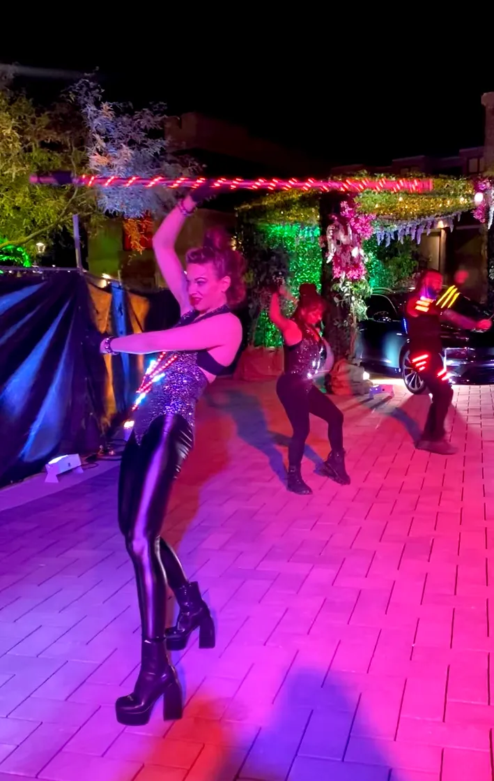 A group of people are dancing on a stage at a party.