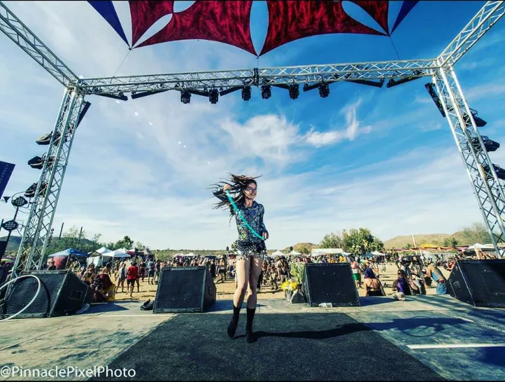 A woman is dancing on a stage at a music festival