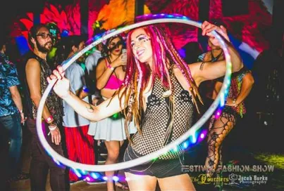 A woman is holding a hula hoop in a crowd of people.