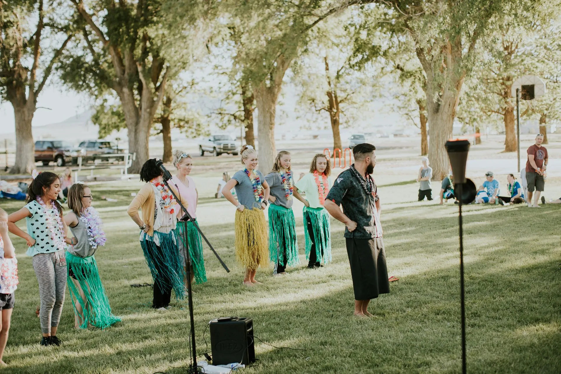 A group of people are standing in a line in a park.