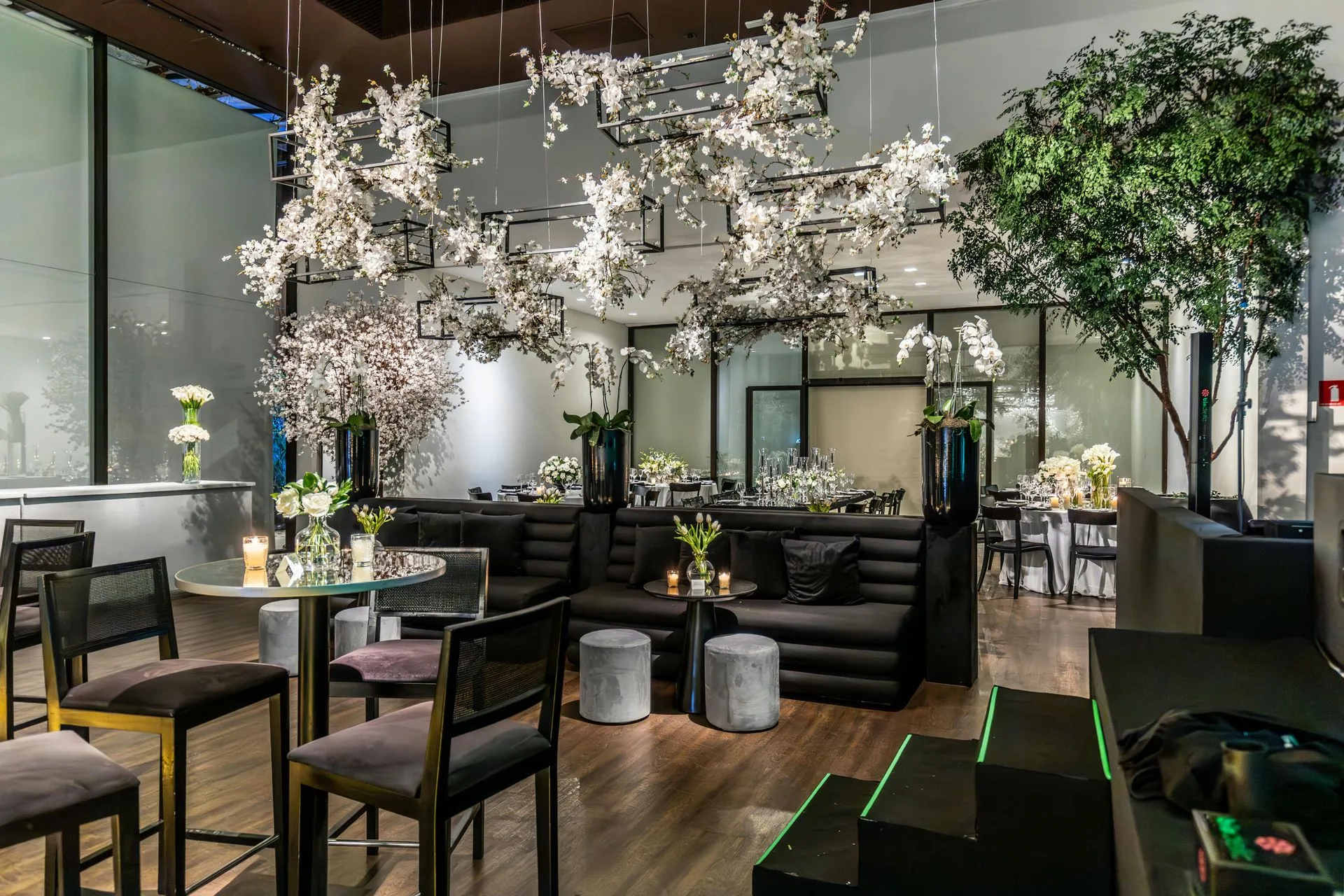 Upscale interior with seating, tables, floral arrangements, and hanging lights.